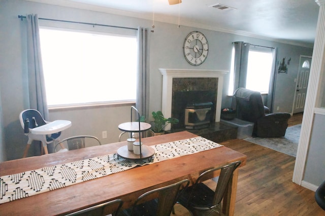 dining room with ornamental molding, dark hardwood / wood-style floors, ceiling fan, and a fireplace