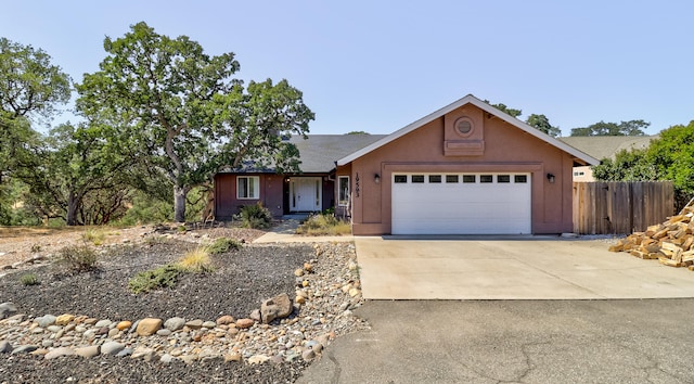 single story home featuring concrete driveway, an attached garage, fence, and stucco siding