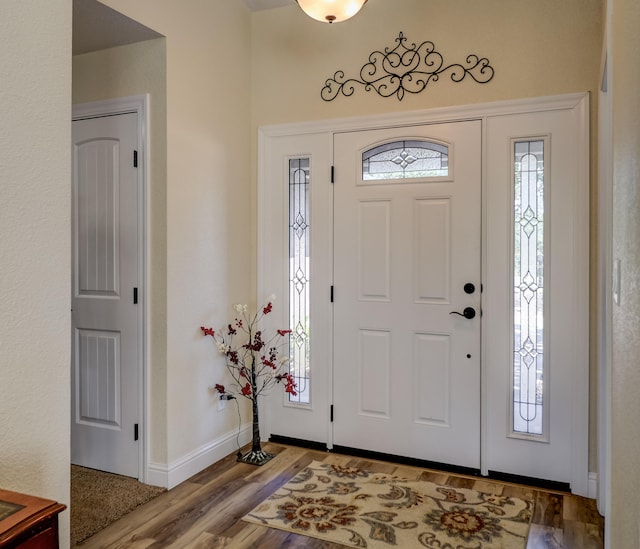 foyer entrance with baseboards and wood finished floors