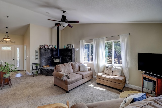 living room with lofted ceiling, carpet flooring, a wood stove, and baseboards