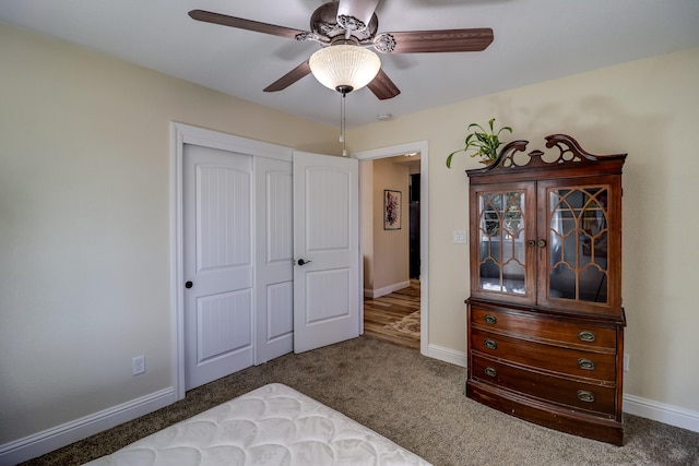 carpeted bedroom with a ceiling fan, baseboards, and a closet