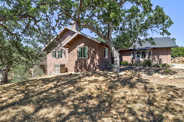 exterior space featuring stucco siding and central air condition unit