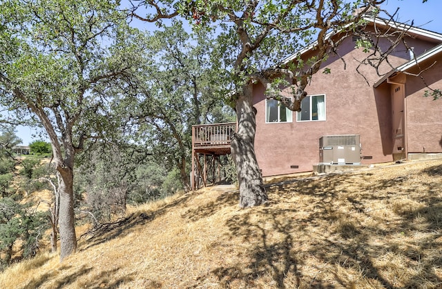 view of home's exterior with a deck, central AC, crawl space, and stucco siding