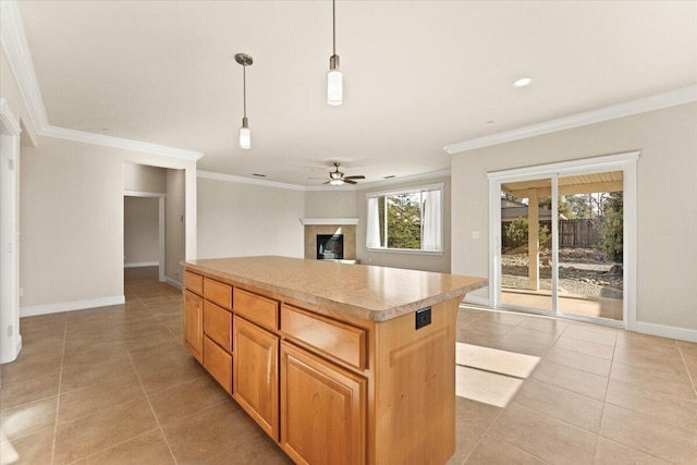 kitchen with hanging light fixtures, ornamental molding, ceiling fan, and a kitchen island