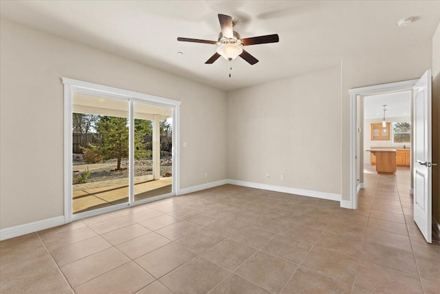 spare room with ceiling fan and light tile patterned flooring