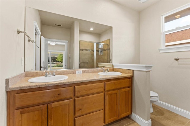 bathroom with tile patterned flooring, toilet, vanity, and a shower with shower door