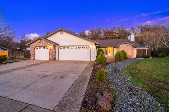 ranch-style house with a garage and a lawn