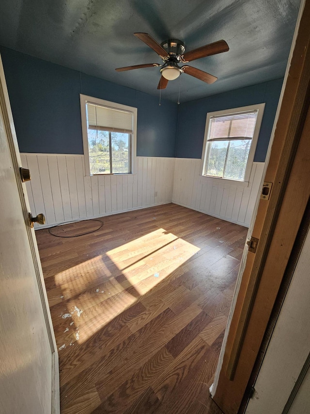 unfurnished room with ceiling fan, hardwood / wood-style flooring, and a healthy amount of sunlight