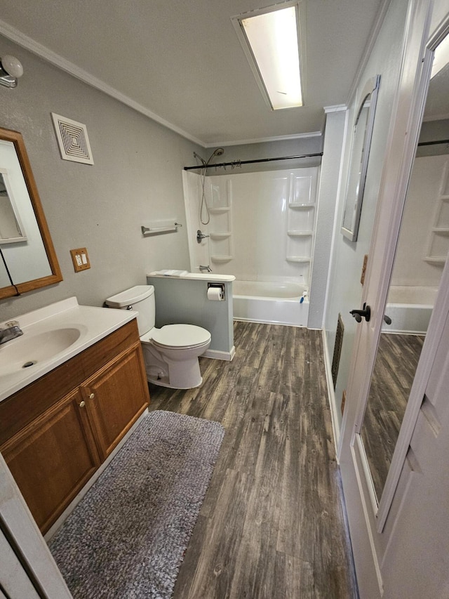 full bathroom featuring hardwood / wood-style floors, crown molding, toilet, and shower / bath combination