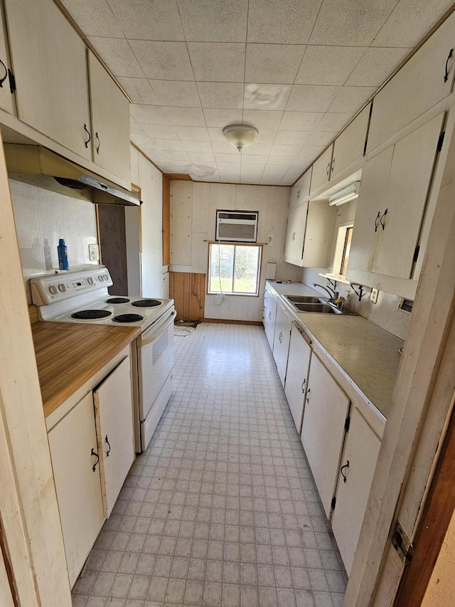 kitchen featuring a drop ceiling, sink, white electric range, and a wall mounted air conditioner