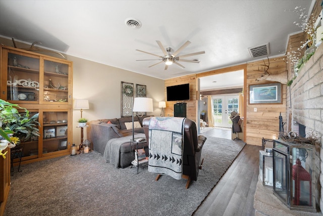 living room with french doors, ceiling fan, wood walls, and hardwood / wood-style flooring