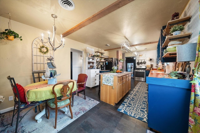 kitchen with beamed ceiling, appliances with stainless steel finishes, and a notable chandelier