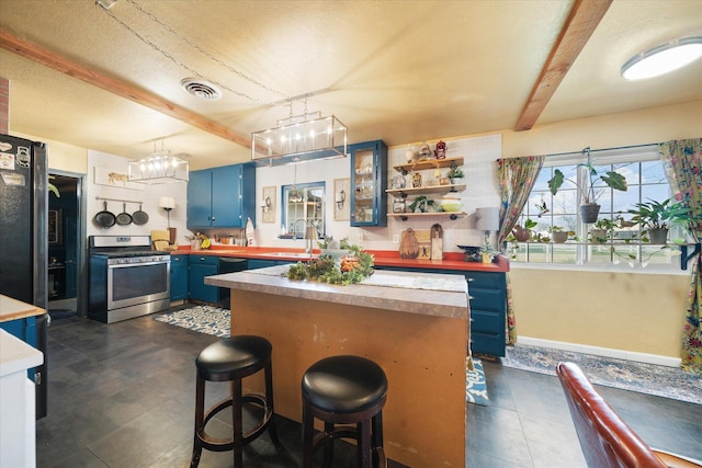 kitchen with a breakfast bar, beamed ceiling, sink, stainless steel appliances, and blue cabinetry