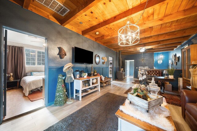 living room featuring wood ceiling, beam ceiling, an inviting chandelier, and light hardwood / wood-style flooring