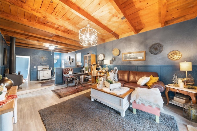 living room featuring beamed ceiling, wooden ceiling, an inviting chandelier, and a wood stove