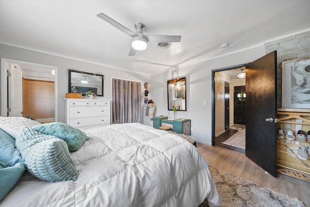 bedroom featuring hardwood / wood-style floors, crown molding, and ceiling fan