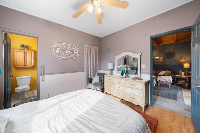 bedroom with ceiling fan, connected bathroom, and light wood-type flooring