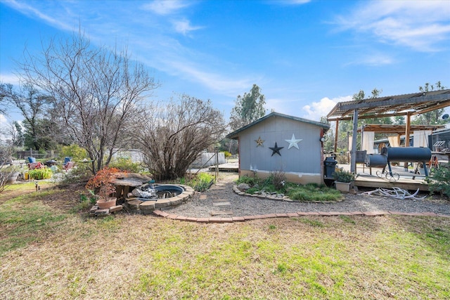 view of yard featuring a deck and a storage unit