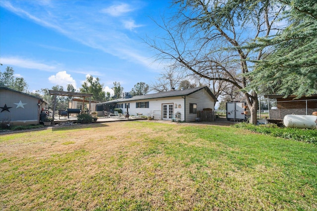 back of house with a pergola, a lawn, and french doors