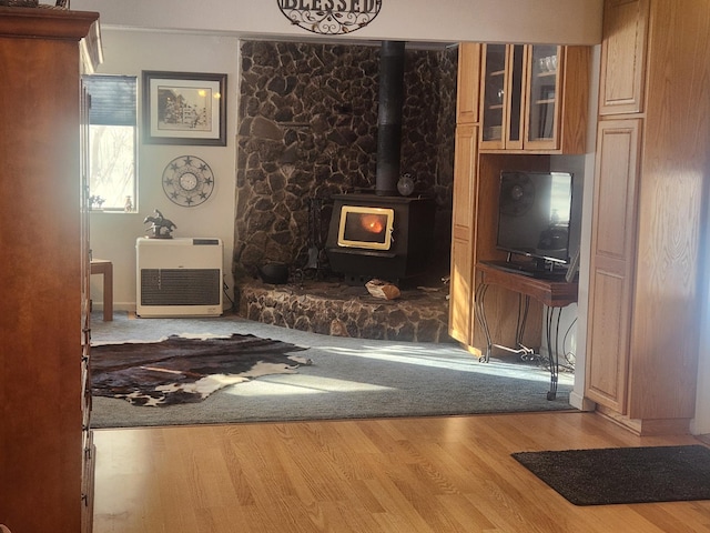 living room with light hardwood / wood-style floors and a wood stove