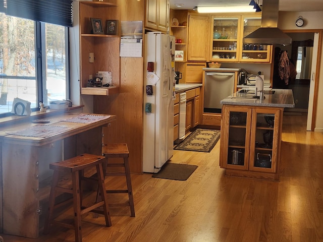 kitchen with light hardwood / wood-style flooring, island range hood, white fridge with ice dispenser, an island with sink, and a kitchen bar