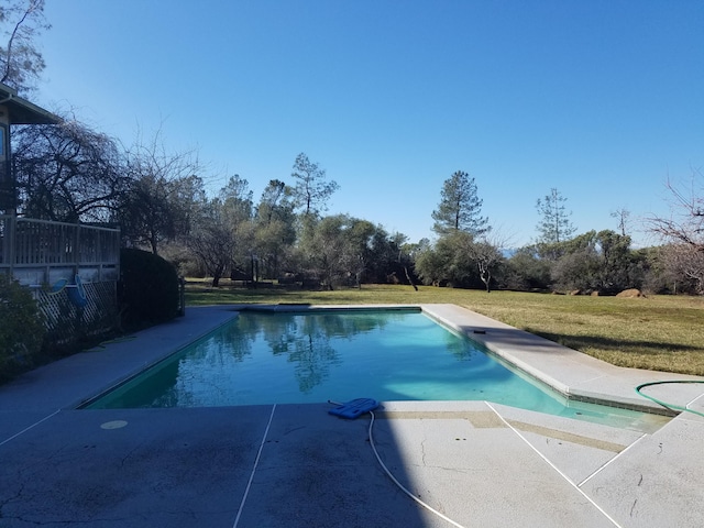 view of swimming pool featuring a yard