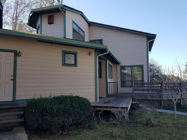 rear view of property featuring a wooden deck