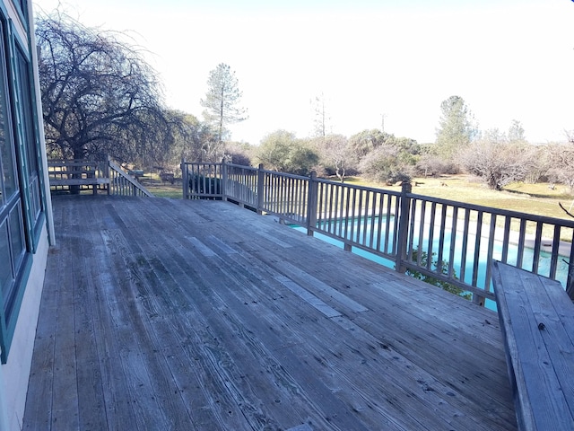 wooden terrace featuring a fenced in pool