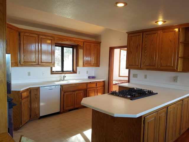 kitchen with sink, white dishwasher, kitchen peninsula, and stainless steel gas cooktop