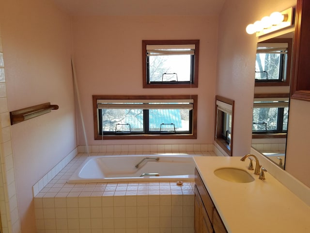 bathroom with a relaxing tiled tub and vanity