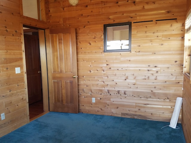 empty room with carpet floors and wooden walls