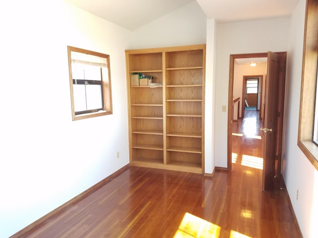 empty room with lofted ceiling and dark hardwood / wood-style flooring