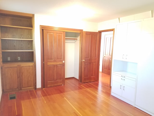 unfurnished bedroom featuring hardwood / wood-style floors and a closet