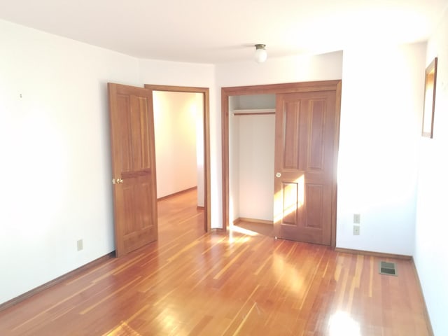 unfurnished bedroom with hardwood / wood-style floors and a closet