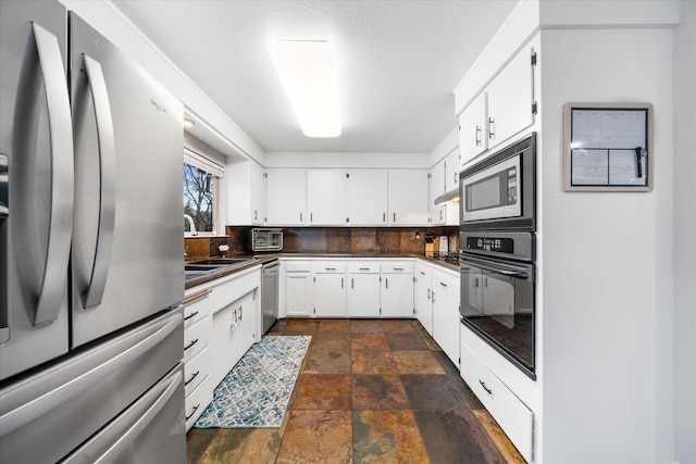 kitchen featuring tasteful backsplash, appliances with stainless steel finishes, sink, and white cabinets