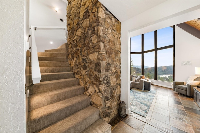 stairs with a mountain view and high vaulted ceiling