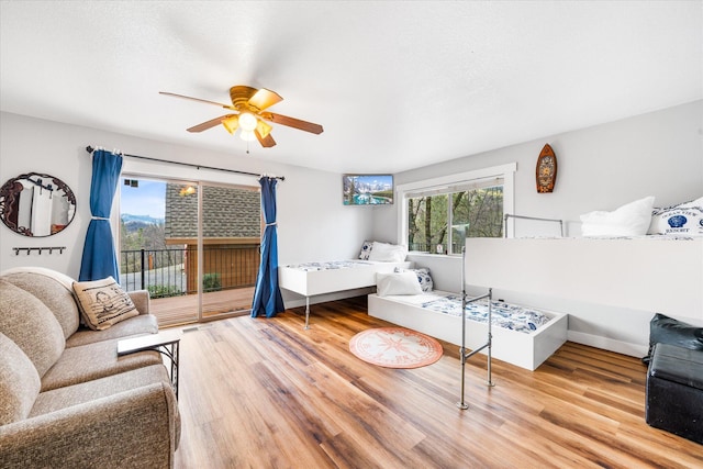 bedroom featuring access to exterior, hardwood / wood-style flooring, and ceiling fan