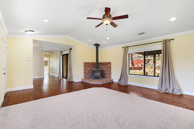 unfurnished living room featuring lofted ceiling, a wood stove, ornamental molding, dark hardwood / wood-style floors, and ceiling fan