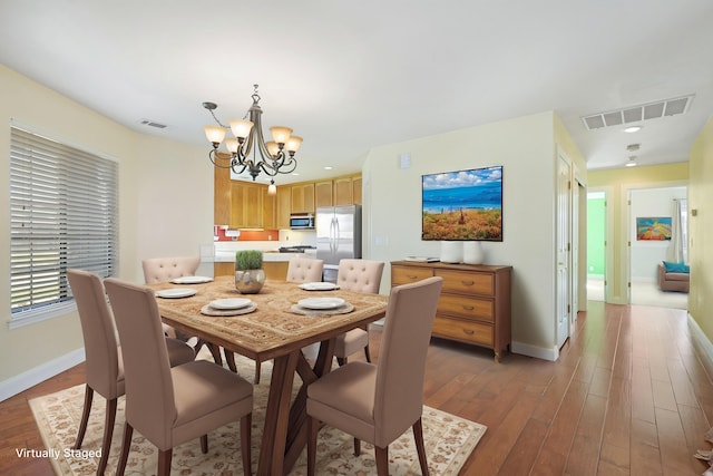 dining area featuring an inviting chandelier and dark hardwood / wood-style flooring