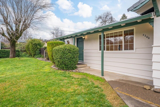 property entrance with a lawn