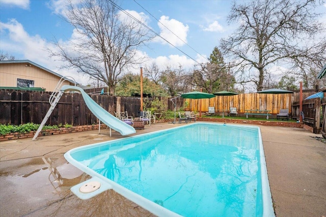 view of swimming pool with a water slide and a patio