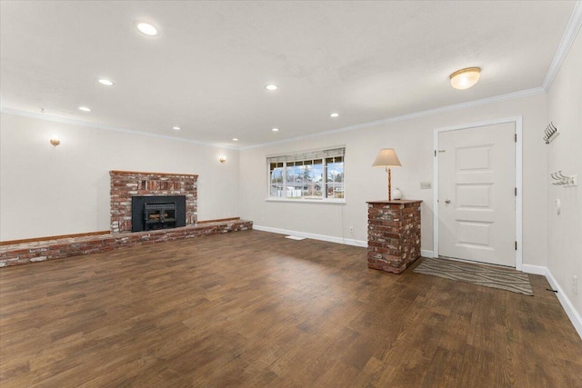 unfurnished living room with a brick fireplace, crown molding, and dark hardwood / wood-style floors