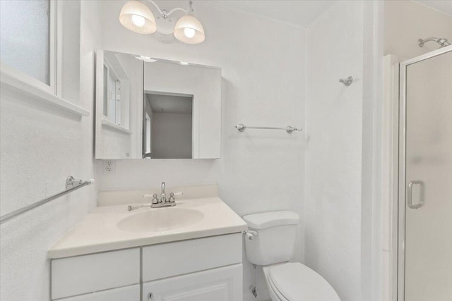 bathroom with a shower with door, vanity, and toilet