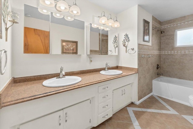 full bathroom featuring tile patterned flooring, tiled shower / bath, vanity, and toilet