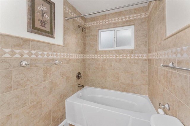 bathroom featuring tiled shower / bath and tile walls