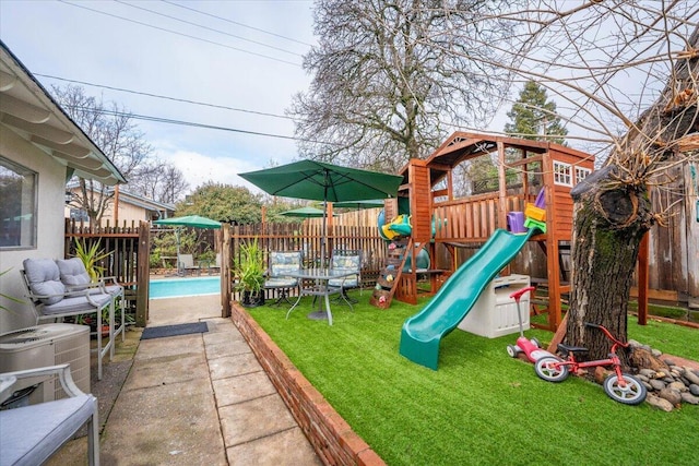 view of jungle gym featuring a fenced in pool, a yard, central AC unit, and a patio area