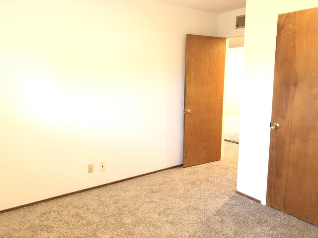 unfurnished bedroom with visible vents, carpet flooring, and baseboards