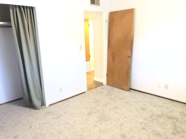 unfurnished bedroom featuring baseboards, visible vents, and carpet