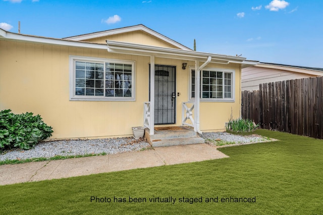 view of front of home featuring a front yard and fence