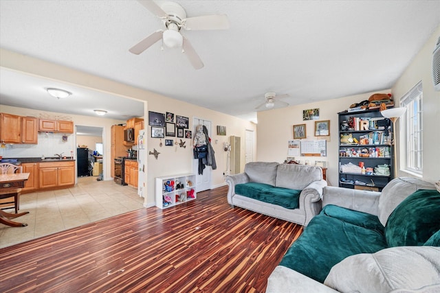 living room featuring light wood-type flooring and a ceiling fan